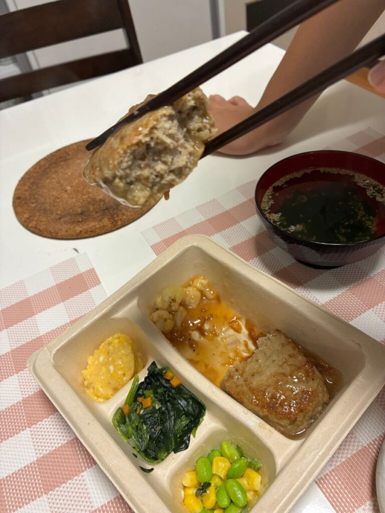 ハンバーグを割り、箸で持ち上げたところ。